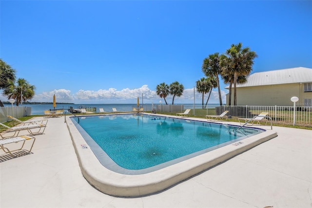 view of pool featuring a patio and a water view