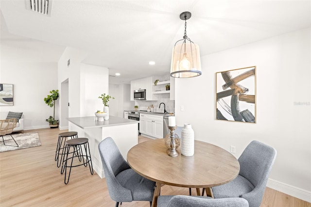 dining room featuring sink and light wood-type flooring