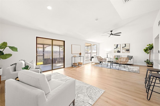 living room with ceiling fan, lofted ceiling, and light hardwood / wood-style flooring