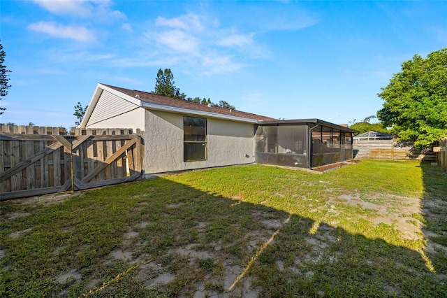 back of house featuring a sunroom and a yard