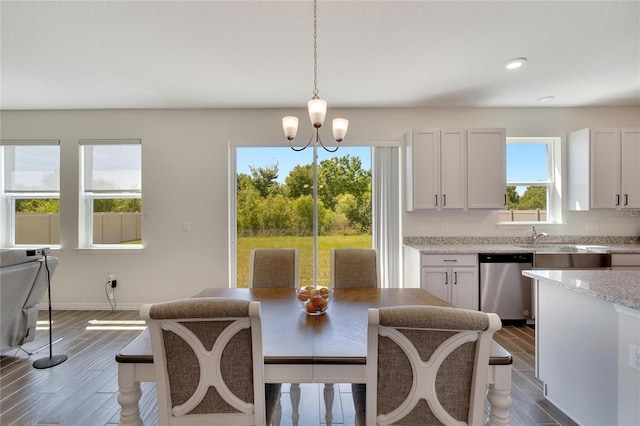 dining area featuring dark wood-type flooring and an inviting chandelier