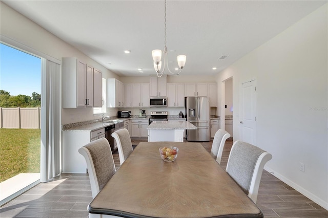 dining room with an inviting chandelier, sink, and plenty of natural light