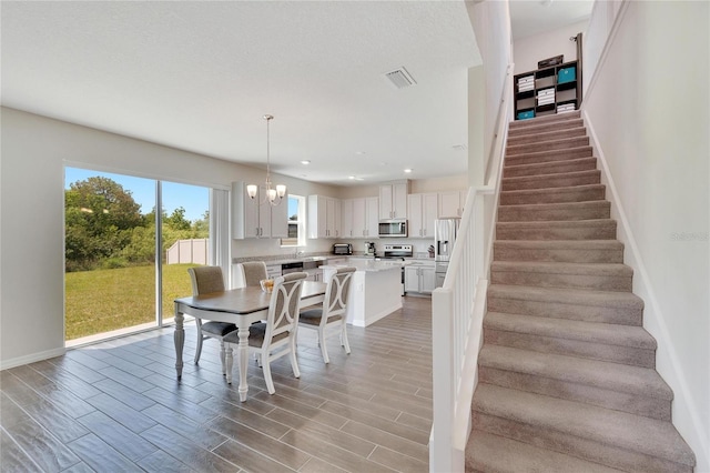 dining area with an inviting chandelier and light hardwood / wood-style floors