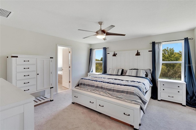 carpeted bedroom featuring ceiling fan and ensuite bath