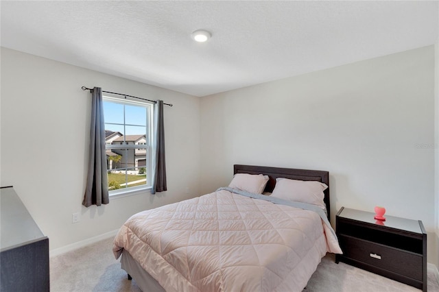 bedroom featuring light carpet and a textured ceiling