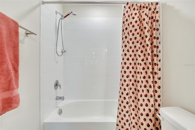 bathroom featuring toilet and tiled shower / bath combo