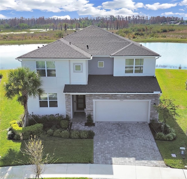 view of front facade with a garage, a water view, and a front yard