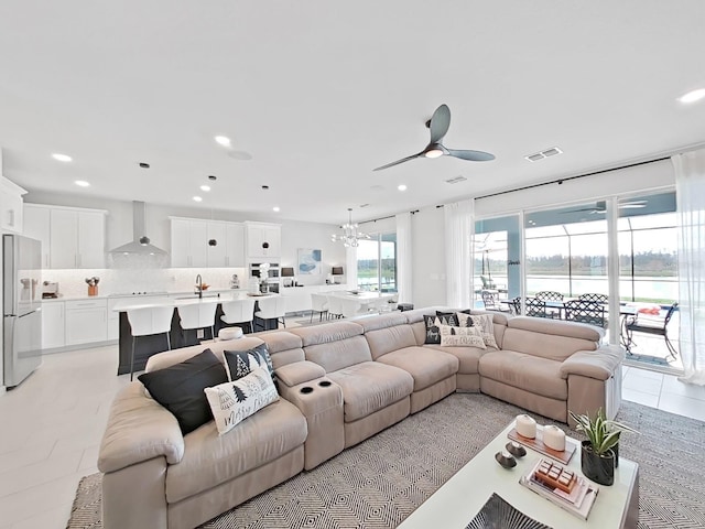 living room with sink and ceiling fan with notable chandelier