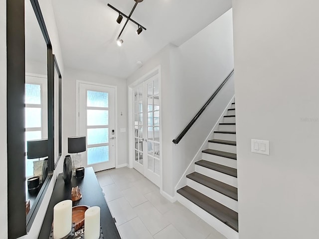 foyer entrance featuring french doors and rail lighting