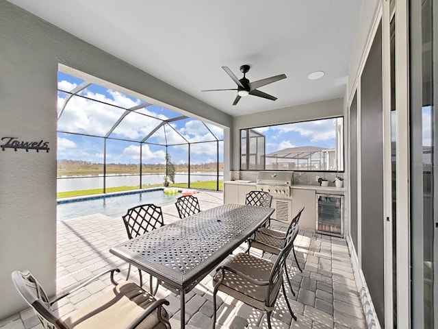 sunroom / solarium with a water view, wine cooler, and ceiling fan