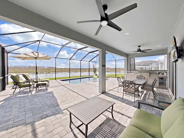 view of patio / terrace with a water view, area for grilling, a lanai, and ceiling fan