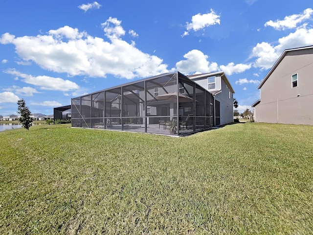 back of house featuring a water view, a yard, and a patio area