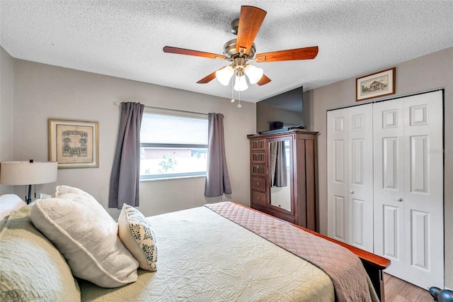 bedroom with ceiling fan, a textured ceiling, a closet, and light hardwood / wood-style flooring