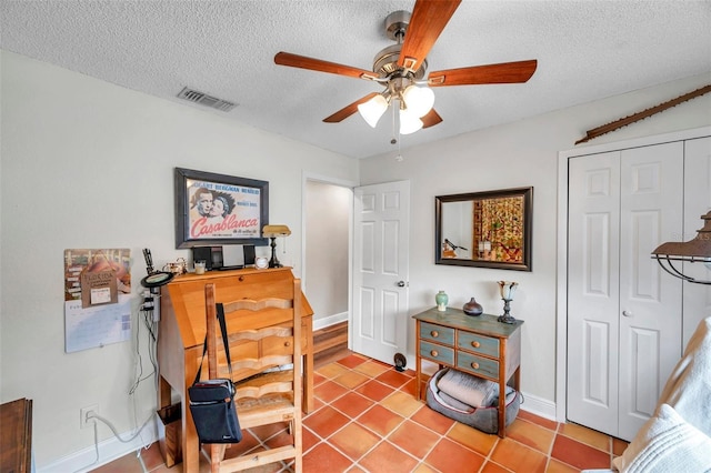 sitting room featuring ceiling fan, a textured ceiling, and light tile patterned floors