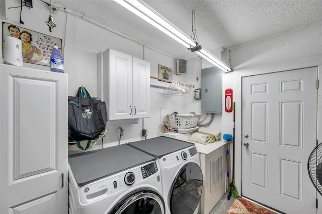 clothes washing area featuring separate washer and dryer, electric panel, cabinets, and a textured ceiling