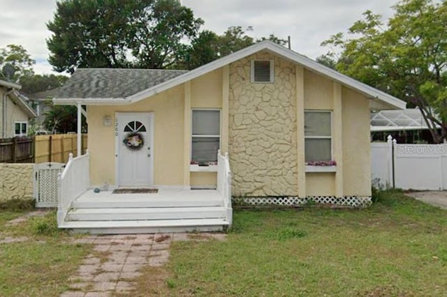 view of front of house featuring a front lawn and a storage unit