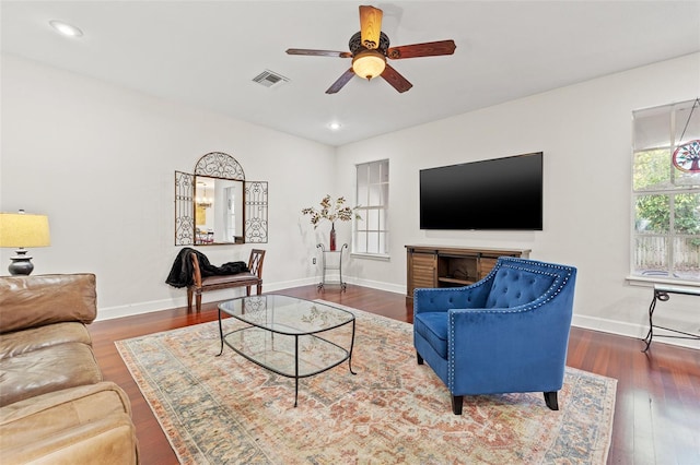 living room with dark hardwood / wood-style flooring and ceiling fan