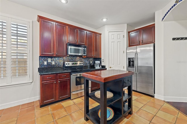 kitchen with backsplash, stainless steel appliances, and light tile patterned floors