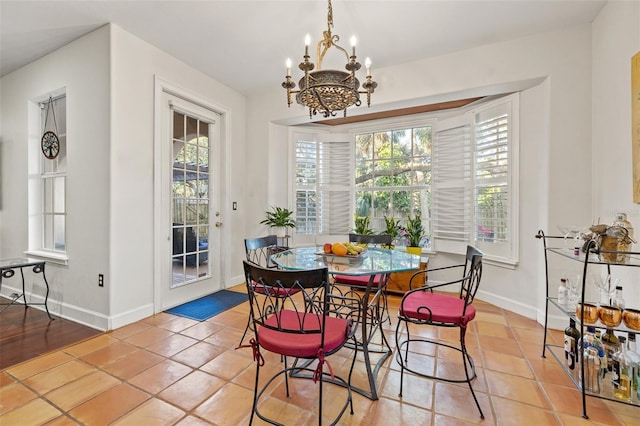 tiled dining room with a chandelier