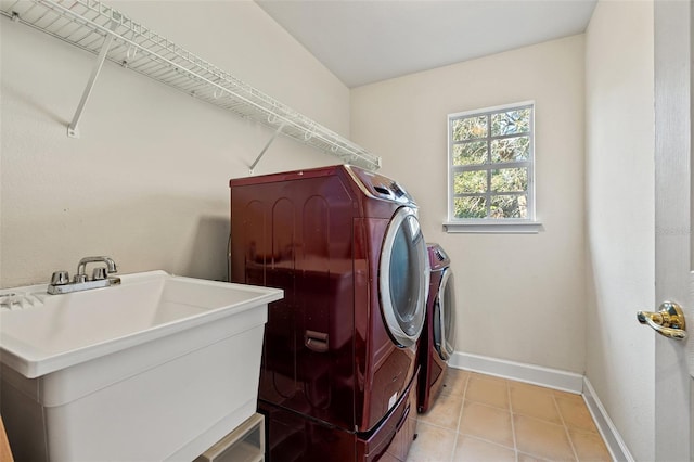 clothes washing area featuring light tile patterned flooring, sink, and washing machine and clothes dryer