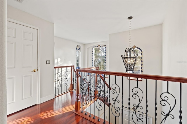 corridor featuring hardwood / wood-style floors and an inviting chandelier