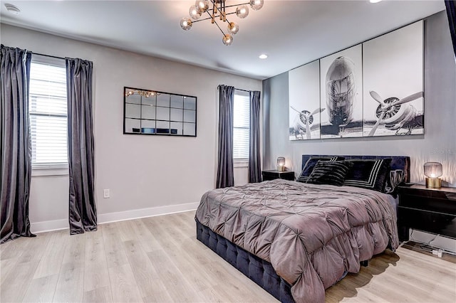 bedroom with a chandelier and light hardwood / wood-style floors