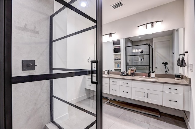 bathroom with vanity, a shower with door, and tile patterned floors