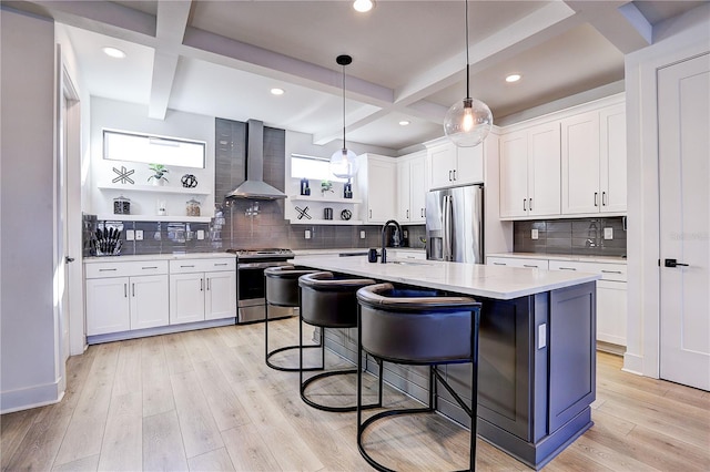 kitchen with white cabinetry, wall chimney exhaust hood, and stainless steel appliances