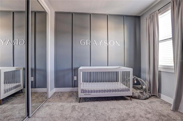 bedroom featuring multiple windows, light colored carpet, and a crib