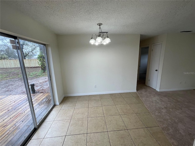 unfurnished room with light tile patterned floors, a textured ceiling, and an inviting chandelier