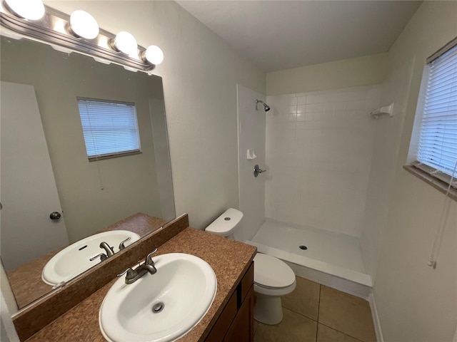 bathroom featuring tiled shower, vanity, toilet, and tile patterned floors