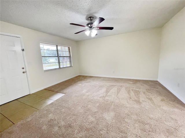 spare room featuring ceiling fan, a textured ceiling, and carpet