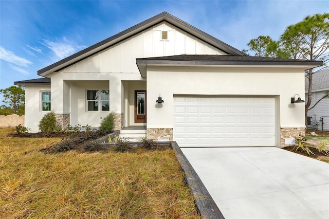 view of front of house featuring a garage, stone siding, board and batten siding, and concrete driveway