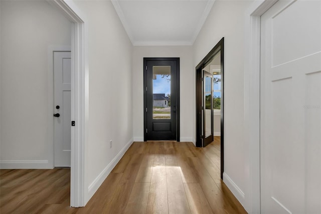 entryway featuring ornamental molding, wood finished floors, and baseboards