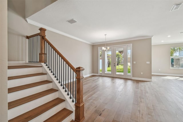 entrance foyer featuring wood-type flooring, plenty of natural light, and crown molding