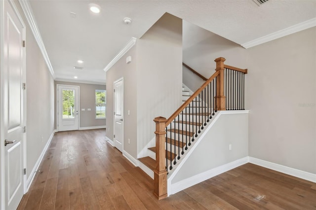 entrance foyer featuring crown molding and hardwood / wood-style flooring