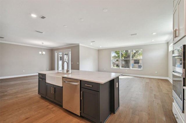 kitchen featuring crown molding, appliances with stainless steel finishes, sink, and light stone counters