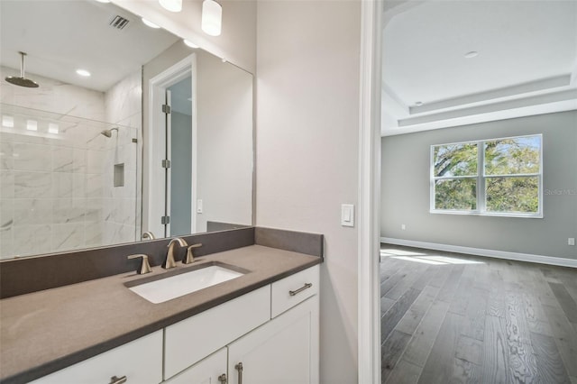 bathroom with vanity, hardwood / wood-style floors, and a tile shower