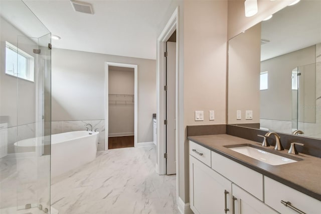 bathroom featuring vanity, independent shower and bath, and a healthy amount of sunlight