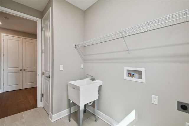 washroom with washer hookup, hookup for an electric dryer, and light tile patterned flooring