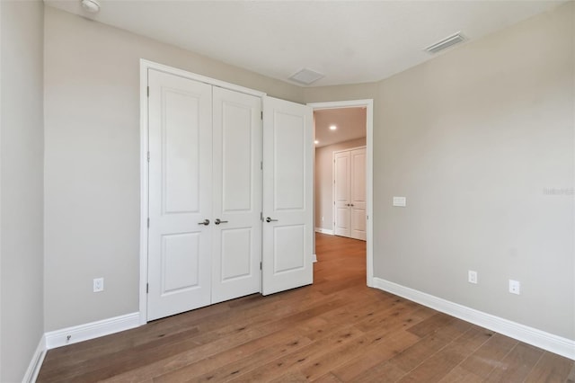 unfurnished bedroom with hardwood / wood-style floors and a closet