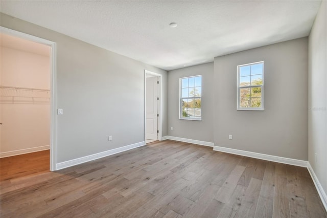 spare room with light hardwood / wood-style floors and a textured ceiling