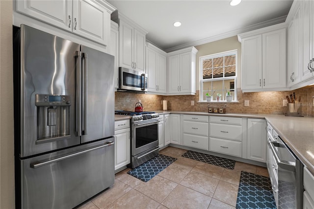 kitchen featuring stainless steel appliances, tasteful backsplash, and white cabinets