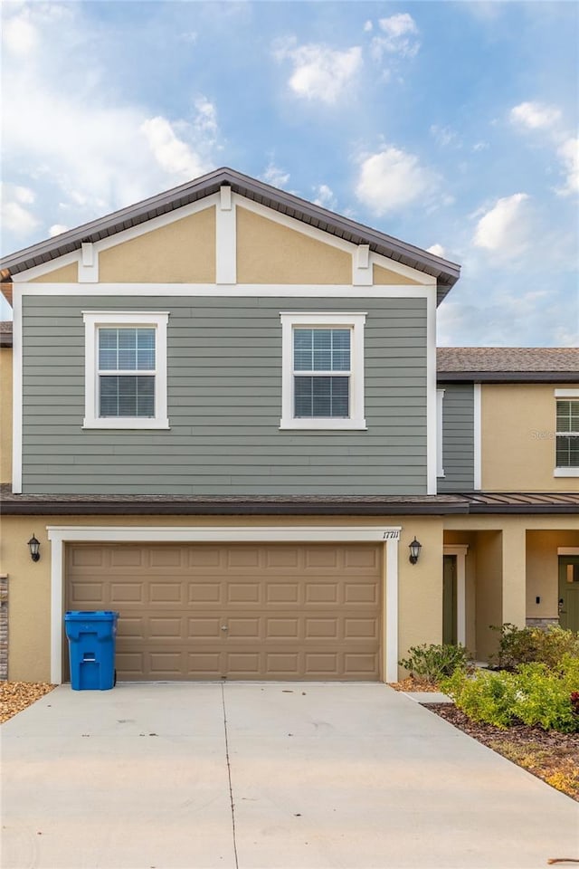 view of front of house featuring a garage, concrete driveway, and stucco siding