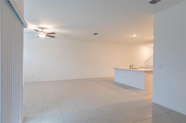 unfurnished room featuring a sink, baseboards, visible vents, and a ceiling fan