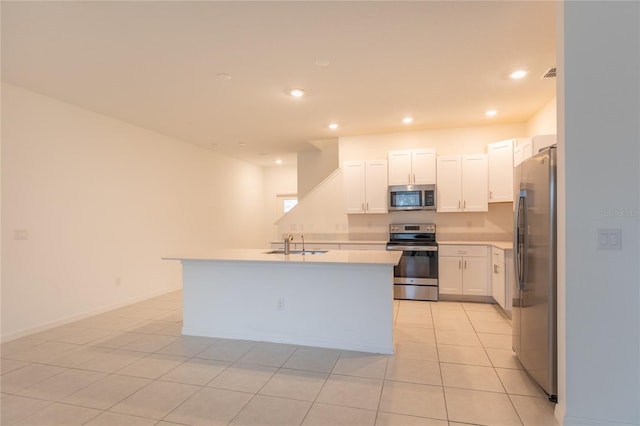 kitchen featuring recessed lighting, light countertops, appliances with stainless steel finishes, white cabinets, and a sink