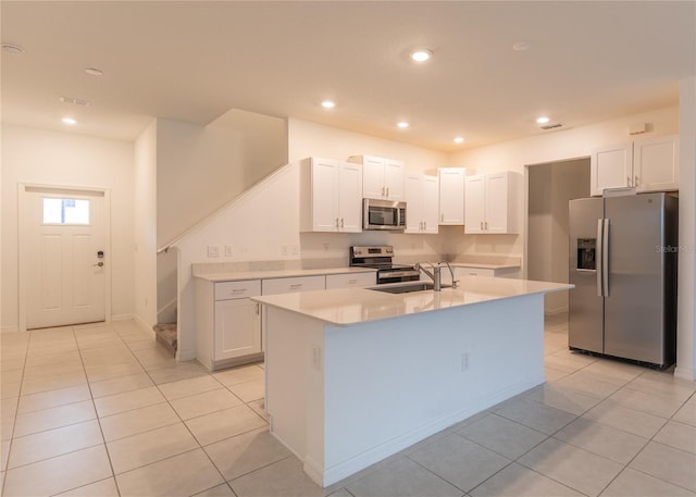 kitchen with light tile patterned floors, light countertops, appliances with stainless steel finishes, white cabinetry, and a sink