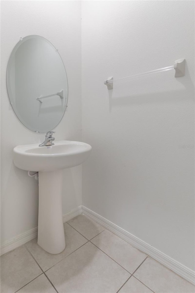 bathroom featuring a sink, baseboards, and tile patterned floors