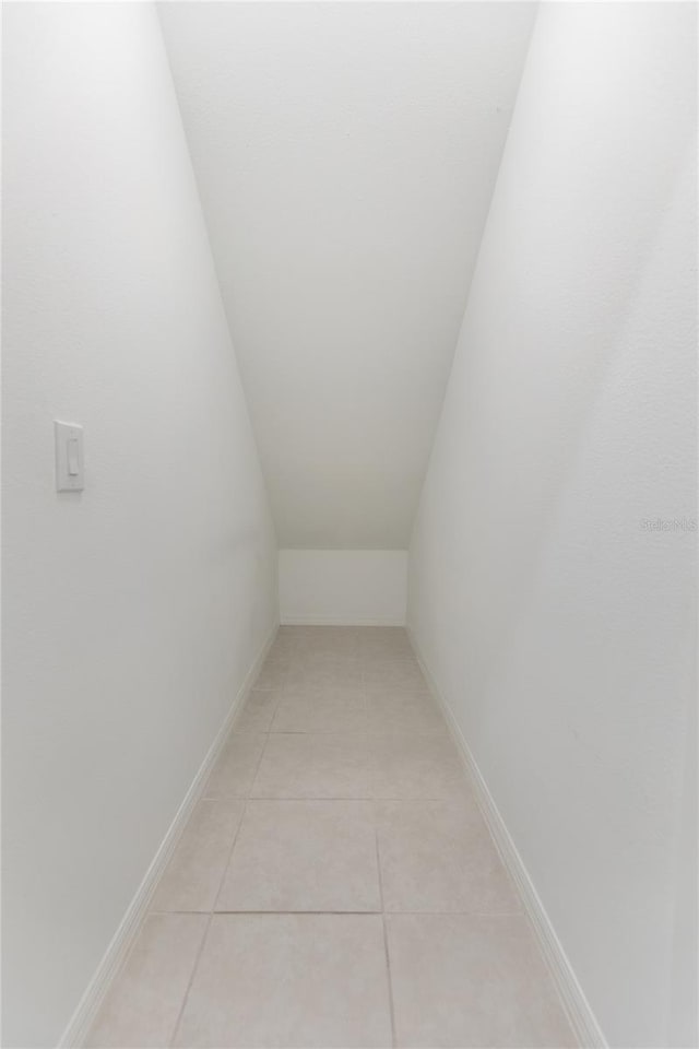 interior space featuring light tile patterned floors and baseboards