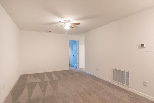 spare room with a ceiling fan, baseboards, visible vents, and carpet flooring